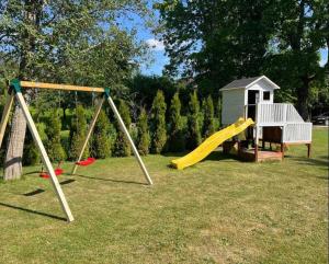 un parque infantil con tobogán y una casa de juegos en Joosepi Holiday House en Silla