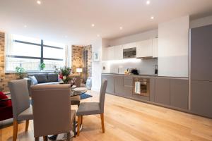 a kitchen and living room with a table and chairs at Camden Town Apartments in London