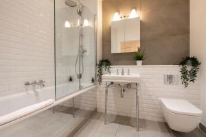 ein Badezimmer mit einem Waschbecken, einer Badewanne und einem WC in der Unterkunft Camden Town Apartments in London