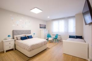 a bedroom with two beds and blue chairs at TELMO nuevo apartamento & parking gratis en BilbaoZorroza in Bilbao