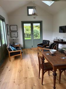 een woonkamer met een houten tafel en stoelen bij Augusta Hut in Auckland