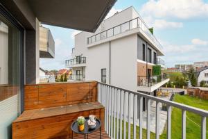 a balcony with a wooden railing and a table at Stylish Apartment with Balcony and Garage in Świnoujście by Renters in Świnoujście