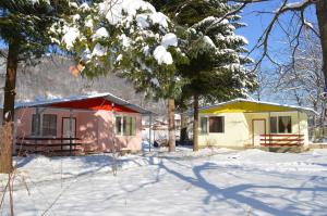ein paar kleine Häuser im Schnee in der Unterkunft Guest House Rainbow in Cherni Osŭm