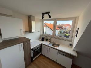 een kleine keuken met een wastafel en een raam bij Gästehaus Stoll in Filderstadt