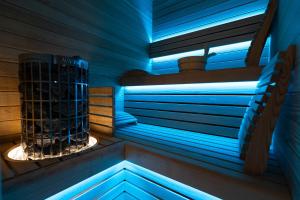 San Barbato Resort Spa & Golf في Lavello: ساونا مع أضواء زرقاء في الغرفة