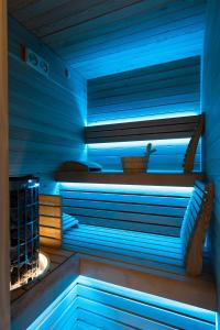 San Barbato Resort Spa & Golf في Lavello: ساونا مع إضاءة زرقاء في غرفة زرقاء