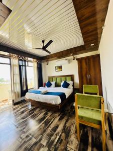 een slaapkamer met een bed en een stoel erin bij Hotel Royal Orbit in Dehradun