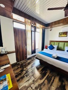 1 dormitorio con 1 cama grande y suelo de madera en Hotel Royal Orbit, en Dehradun