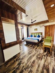 - une chambre avec un lit, un canapé et une chaise dans l'établissement Hotel Royal Orbit, à Dehradun