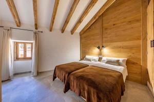 1 dormitorio con 1 cama grande y pared de madera en Townhouse Teluo - In the heart of Pollença, en Pollensa