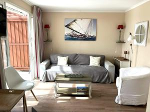 a living room with a couch and a glass coffee table at Appartement familial avec vue sur la mer à Agay - 40 m² + piscine in Agay - Saint Raphael