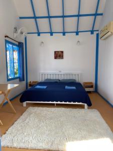 Ko Phangan Beach Cottages في بان تاي: غرفة نوم بسرير ازرق وسجادة