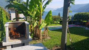 a stone fireplace with a view of a garden at Casa Ramerino in Brissago