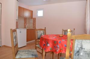 eine Küche mit einem Tisch und einem roten Tischtuch in der Unterkunft Guest House Rainbow in Cherni Osŭm