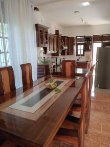 una cocina con una gran mesa de madera y sillas en Jayawardana House, en Matara