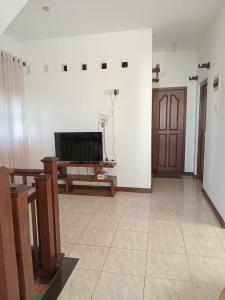 sala de estar con TV y puerta en Jayawardana House, en Matara