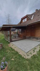 a house with a large patio in the backyard at Any Kulcsosház in Sicasău