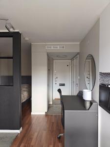 een kamer met een bureau met een spiegel en een bed bij City Center with Stunning Views in Stockholm