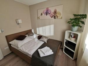 een slaapkamer met een bed met witte lakens en een plant bij Ferienwohnung Schaumburg- Rosenthal in Schaumburg