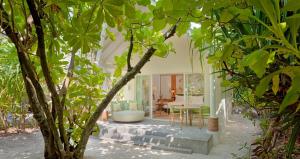 a living room with trees in the foreground at RAAYA By Atmosphere - Premium All Inclusive with Free Transfers in Raa Atoll