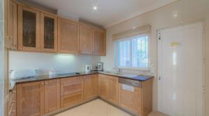 a kitchen with wooden cabinets and a window at Villa Tulipa - luxury golfing resorts in Almancil