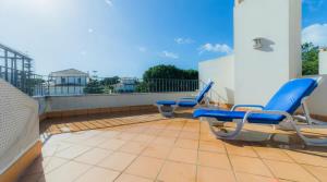 un patio avec des chaises bleues sur un balcon dans l'établissement Villa Tulipa - luxury golfing resorts, à Almancil