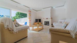 ein Wohnzimmer mit 2 Stühlen und einem Kamin in der Unterkunft Villa Tulipa - luxury golfing resorts in Almancil