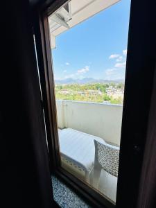 - une vue depuis la fenêtre d'un lit sur un balcon dans l'établissement Hotel Royal Orbit, à Dehradun