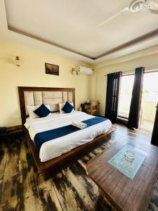 a bedroom with a large bed with blue pillows at Hotel Royal Orbit in Dehradun