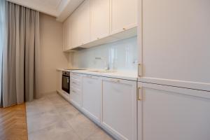 eine Küche mit weißen Schränken und einer Spüle in der Unterkunft Vintage Apartments in Odessa + 53 Fotos