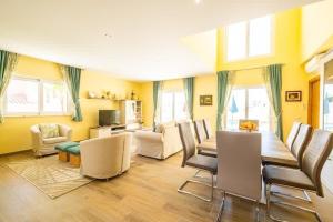- un salon avec des murs jaunes, une table et des chaises dans l'établissement Villa Vida, à Albufeira