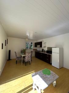 sala de estar amplia con cocina y mesa en La Piaule De Nessadiou en Bourail