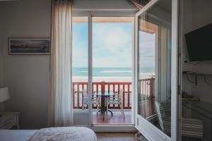 um quarto com uma varanda com vista para o oceano em Hôtel de La Plage em Hossegor