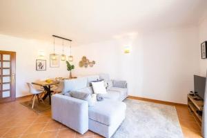 een woonkamer met een witte bank en een tafel bij Villa Baya - Great family complex with communal pool in Albufeira
