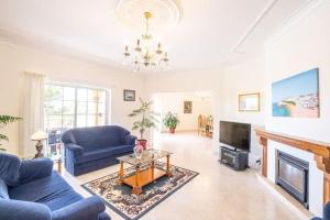 sala de estar con sofás azules y chimenea en Casa Bella Vista - Fantastic spacious villa with beautiful views views of the Algarvian mountains, Monchique, en Estômbar