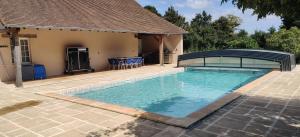 a swimming pool in a yard with a pavilion at La Pouzerie in Thevet-Saint-Julien