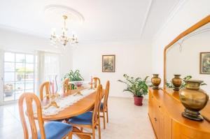 un comedor con una gran mesa de madera y sillas en Casa Bella Vista - Fantastic spacious villa with beautiful views views of the Algarvian mountains, Monchique, en Estômbar