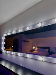 a mirror with lights on top of a bedroom at The Hideaway by Boutique 56 in Liverpool