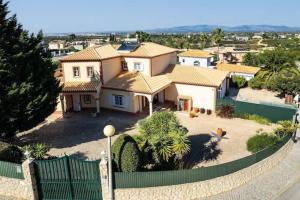 een groot huis met een hek ervoor bij Casa Bella Vista - Fantastic spacious villa with beautiful views views of the Algarvian mountains, Monchique in Estômbar