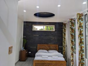 a bedroom with a bed and a black wall at Wellness Luxury Accommodation in Moshi