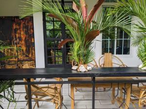 a dining room table with chairs and palm trees at Wellness Luxury Accommodation in Moshi