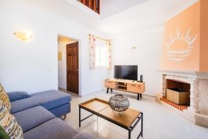 ein Wohnzimmer mit einem blauen Sofa und einem Kamin in der Unterkunft Apartment Marlena - complex great for families in Albufeira