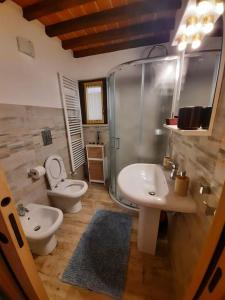 y baño con lavabo, aseo y ducha. en La Casa degli Artisti, appartamento centralissimo, en Montepulciano
