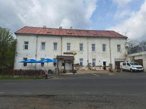 a white building with a red roof and blue umbrellas at Pension U Johnů in Petrovice