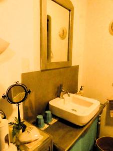 y baño con lavabo y espejo. en Chambre poésie, en Froidchapelle