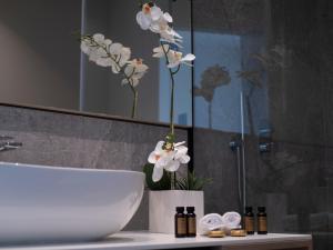 a vase of flowers on a counter in a bathroom at Sea Star Budva in Budva
