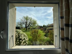 a window with a view of a garden at Gîte de la Valière in Chevigny-en-Valière