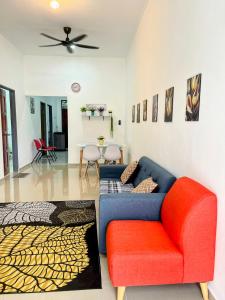 a living room with a couch and a chair at Homestay CikguMa - Netflix & Wifi in Kota Bharu