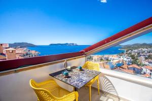 una mesa y sillas en un balcón con vistas al océano en Bella Kaş, en Kas