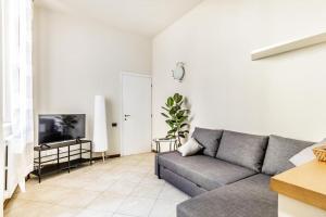 ein Wohnzimmer mit einem Sofa und einem TV in der Unterkunft Family House - Mandala 20min to Duomo in Sesto San Giovanni